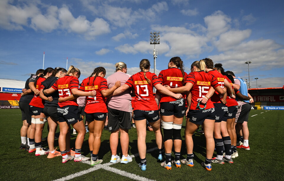 The Munster players and coaches huddle together