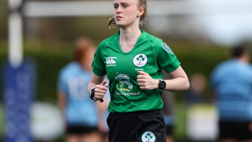 A female referee running on pitch