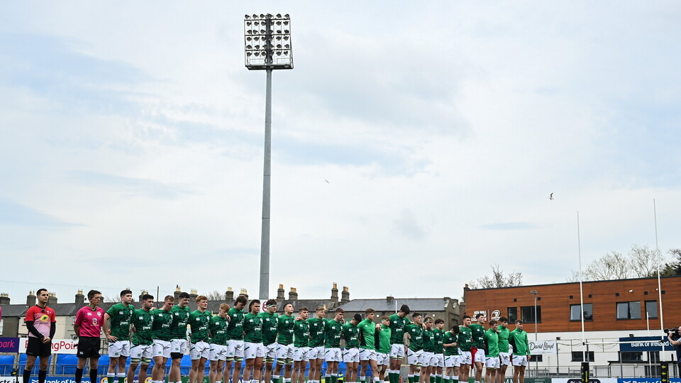 Players in green and white jerseys stand on the pitch before the match.
